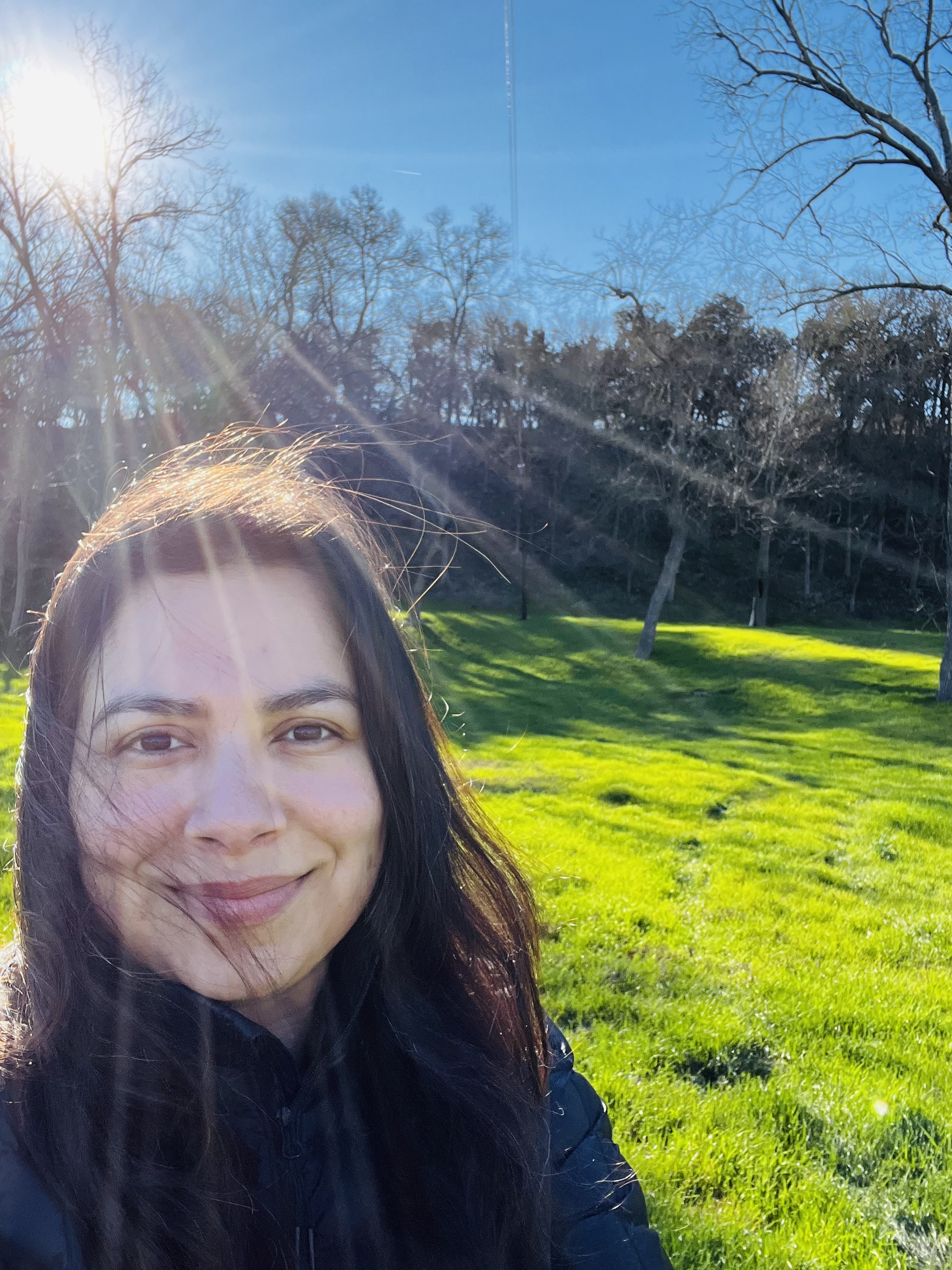 Irma smiling in a sunlit green field