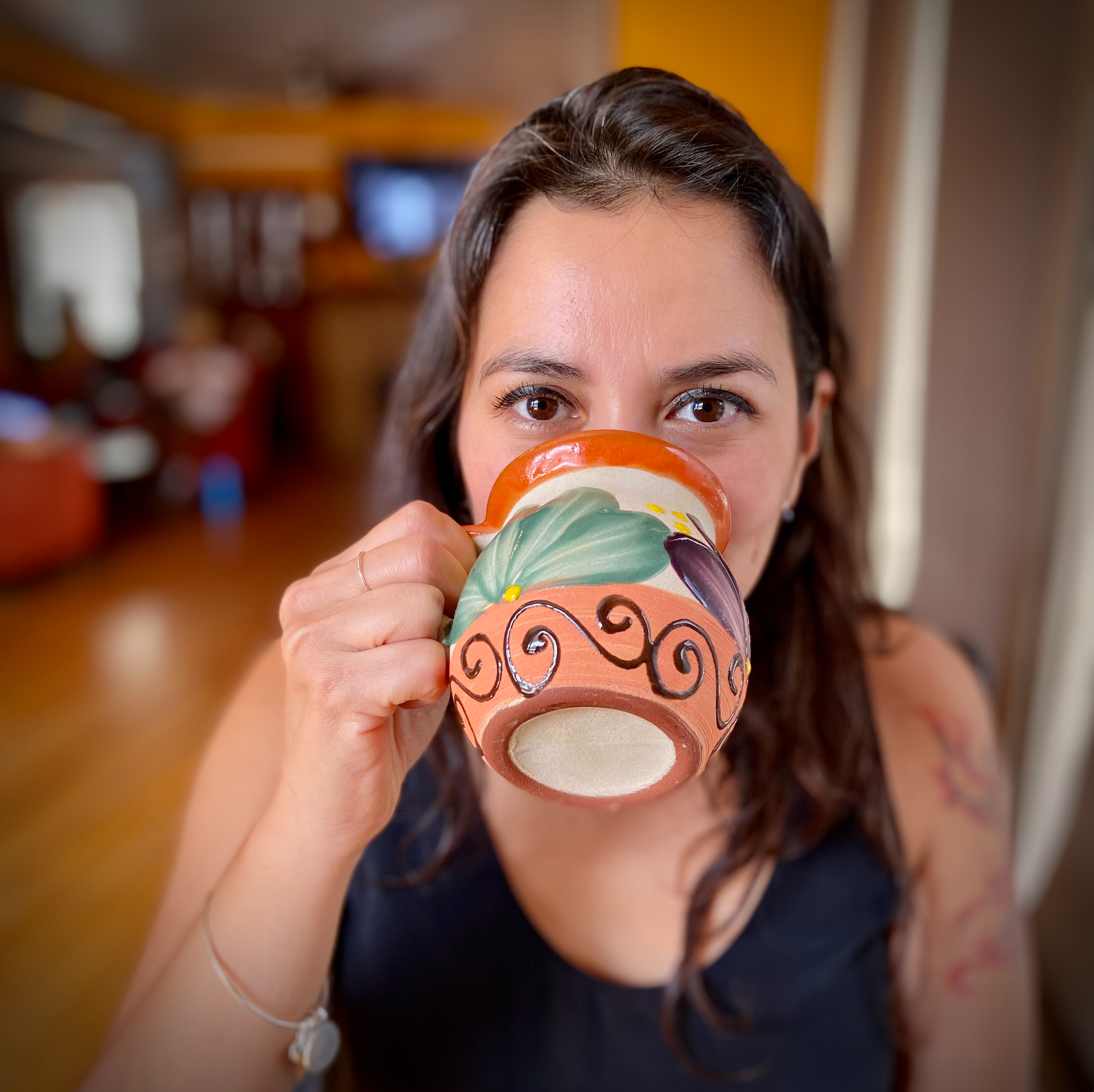 Irma sipping from a hand-painted mug