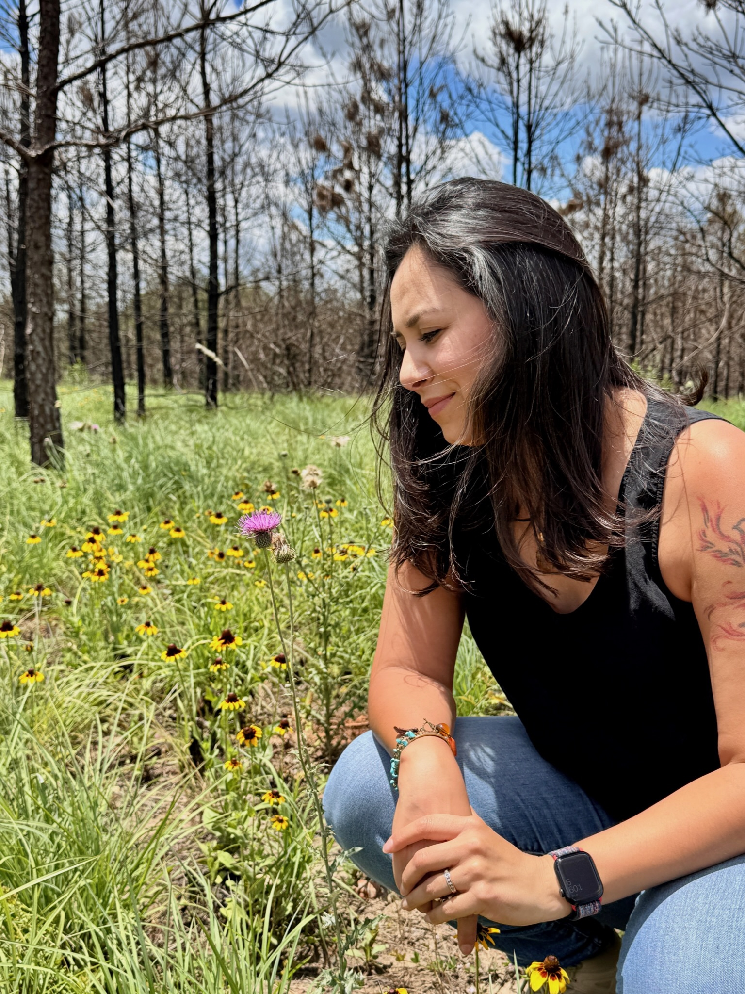 Irma pausing beside wildflowers on a trail