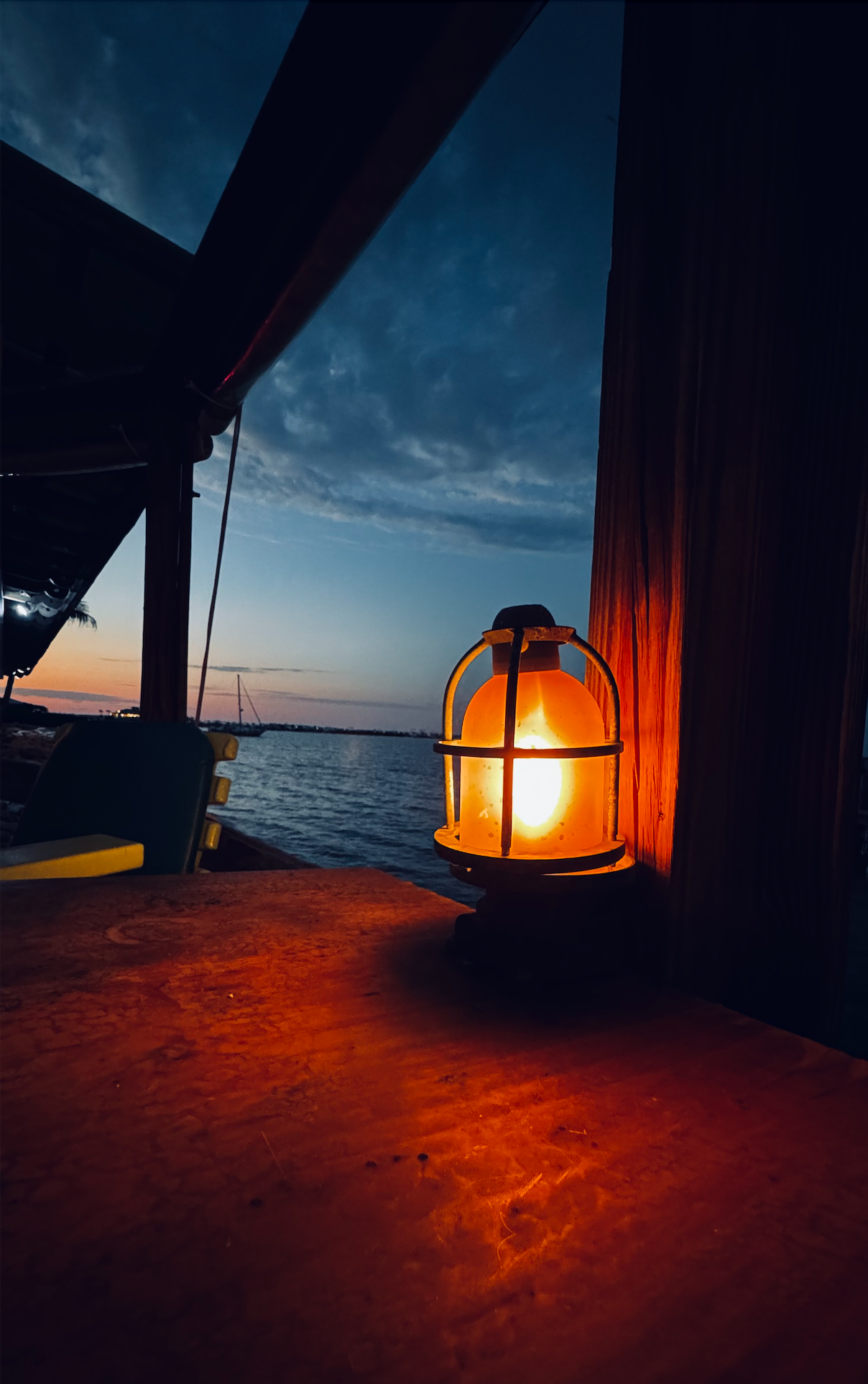 A lantern glowing at dusk over the water