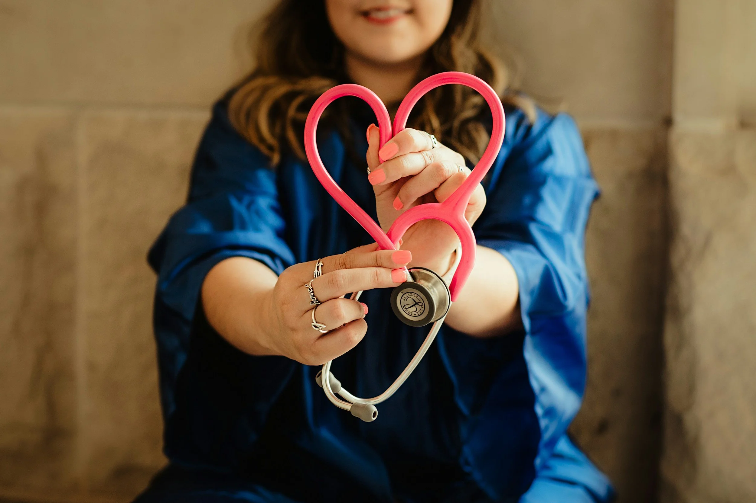 A nurse holding a stethoscope shaped into a heart