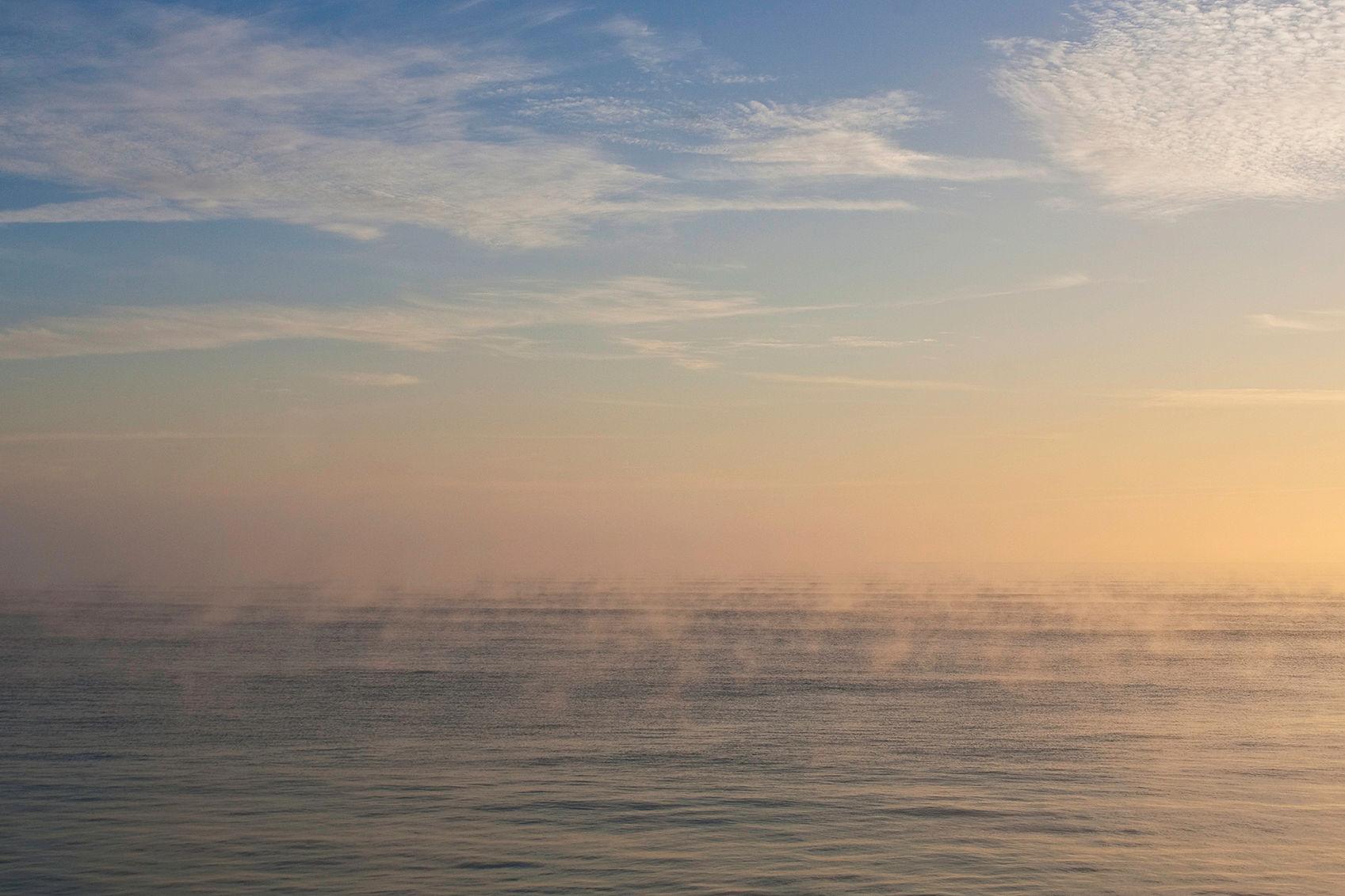 Misty sunrise over calm water
