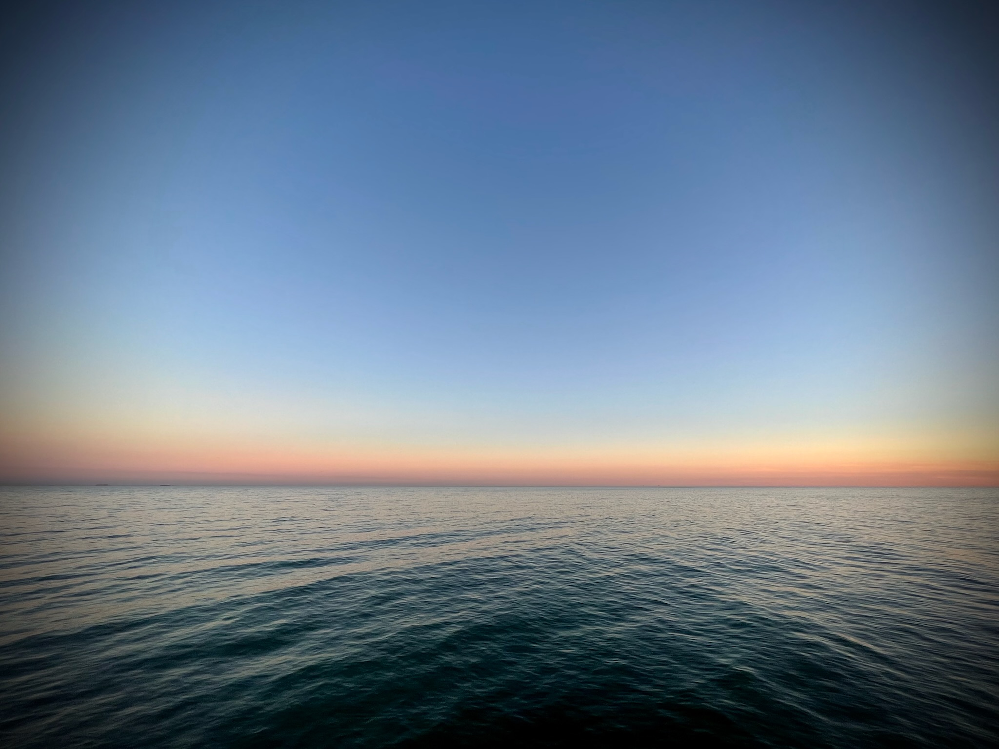 Quiet ocean water at dusk under a soft sky