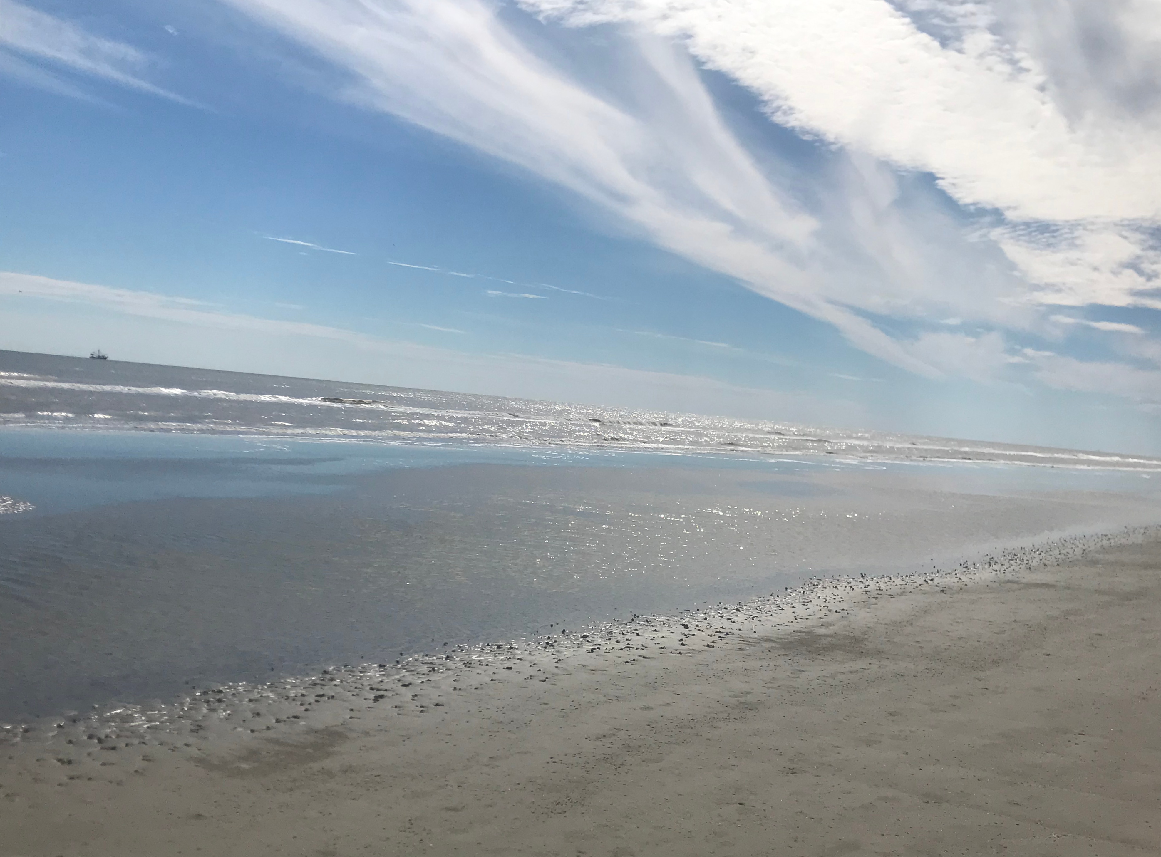Sparkling shoreline and tide pool under a wide sky